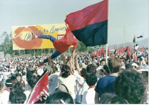 Nicaraguans celebrating the 10th anniversary of the Nicaraguan revolution in Managua. Hundreds of people gathered, waving the FSLM flag.