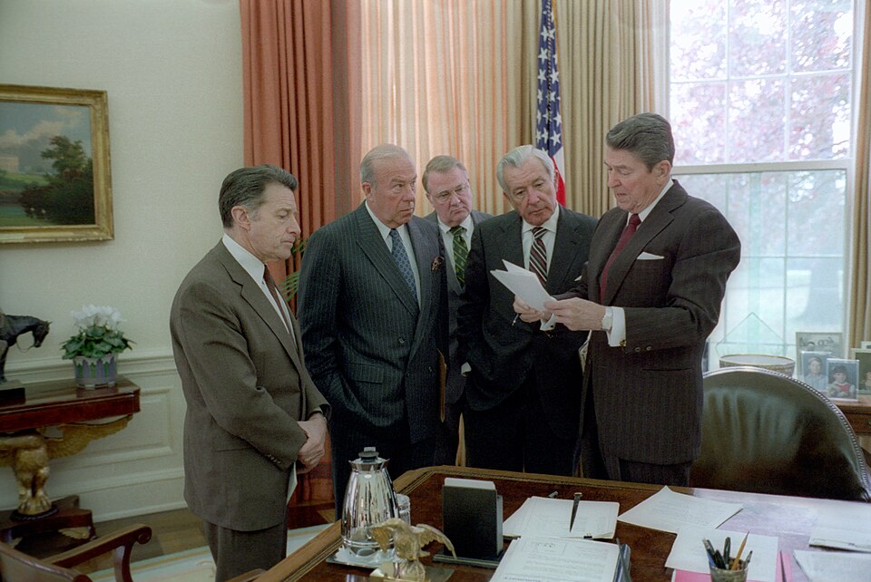 Reagan discussing the Iran Contra Scandal's outbreak with four close advisors in the Oval Office. Those advisors include Caspar Weinberger, George Shultz, Ed Meese, and Don Regan.